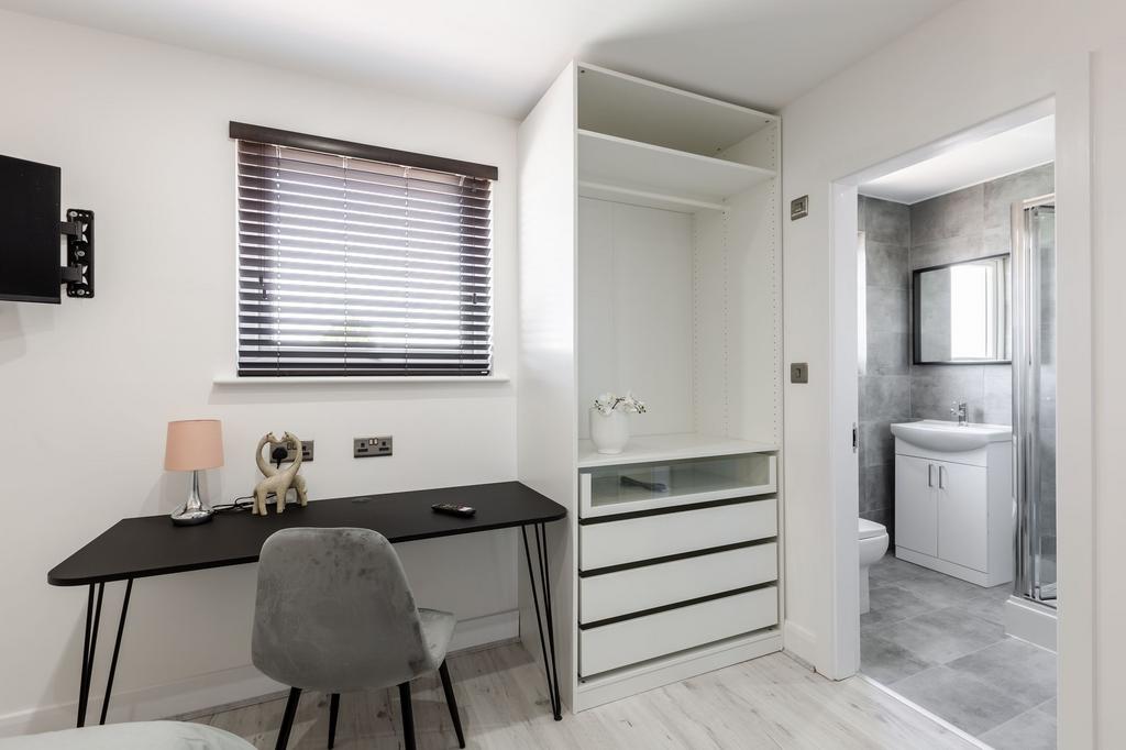 A modern bathroom with a sleek sink unit, a lar...