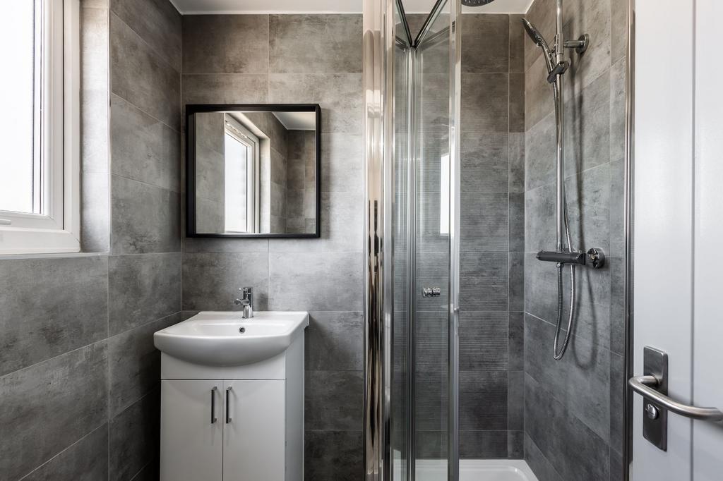 A modern bathroom featuring a spacious shower u...