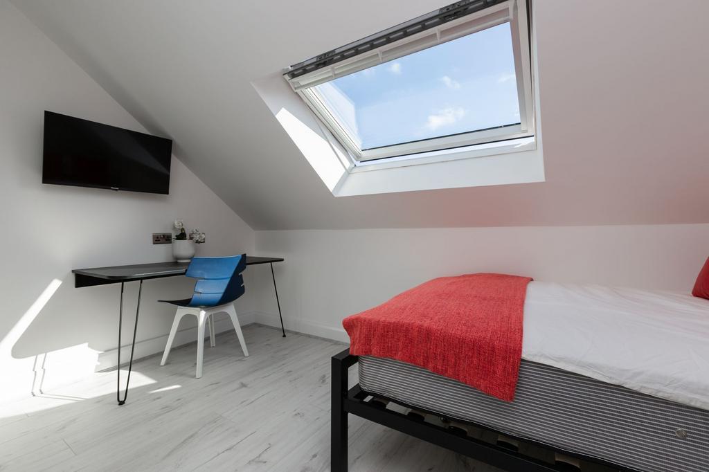 Bright and modern single bedroom featuring a co...