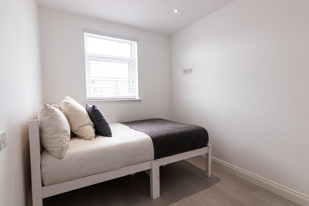 Bright, simply styled single bedroom with a com...