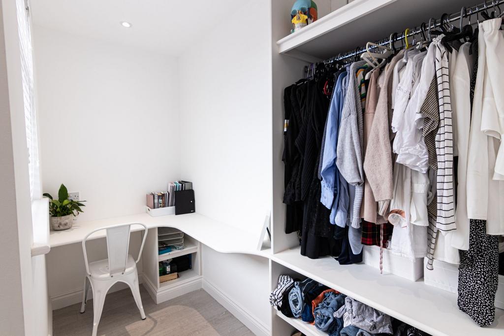 Bright, neatly organised bedroom nook with a bu...
