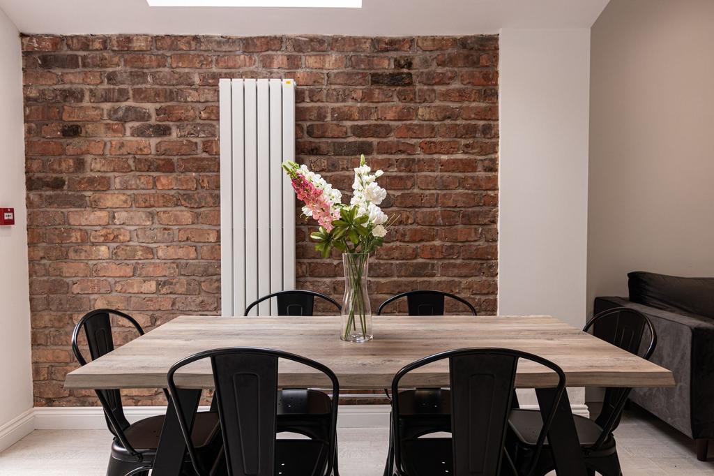 Stylish dining area with a rustic exposed brick...