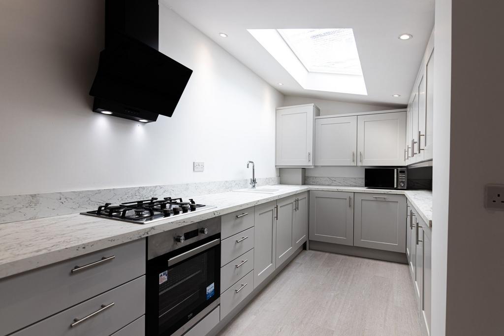 Bright modern galley kitchen with marble-effect...