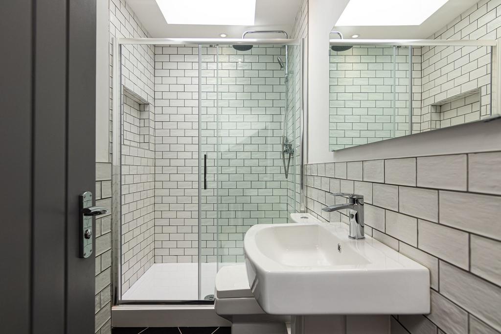 Bright, modern bathroom with full walk-in glass...
