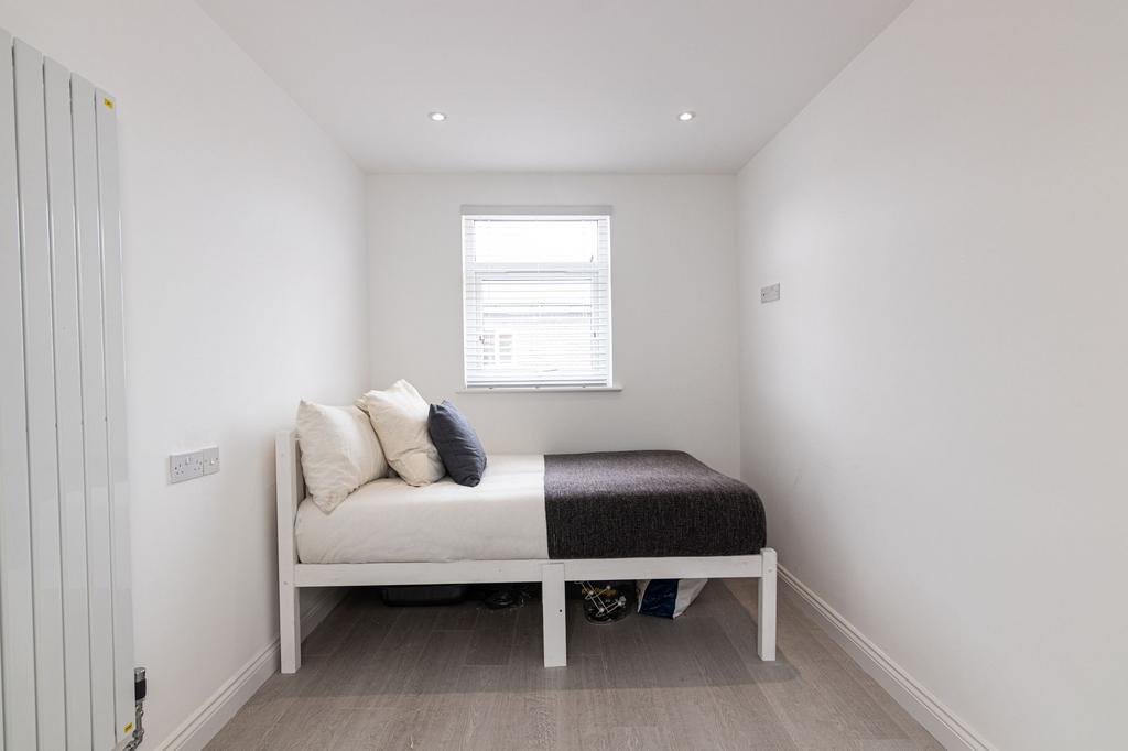 Bright, simply furnished single bedroom with a ...