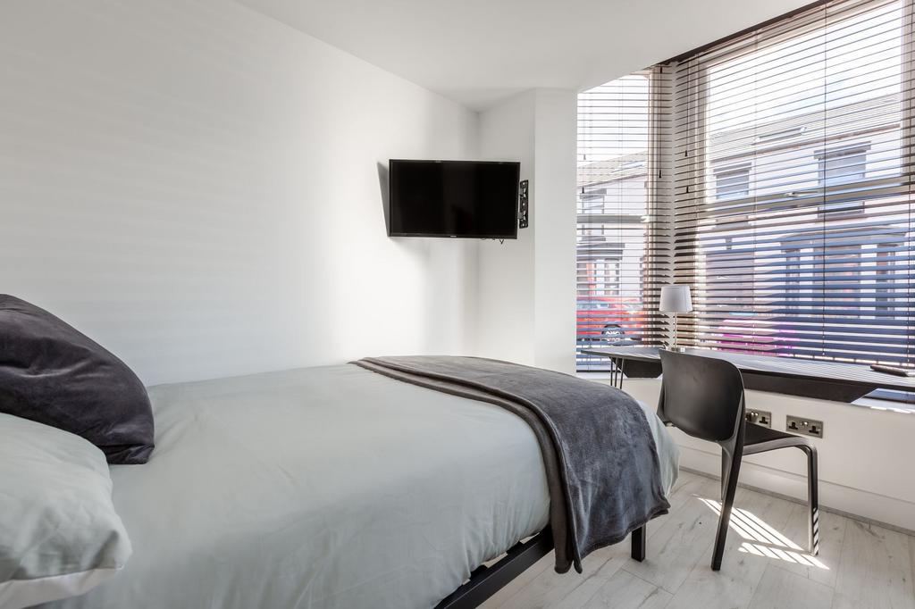 Bright, modern bedroom with a large window lett...