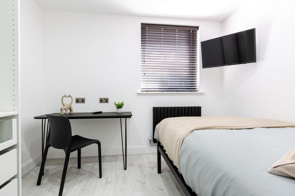 A bright and modern single bedroom featuring a ...