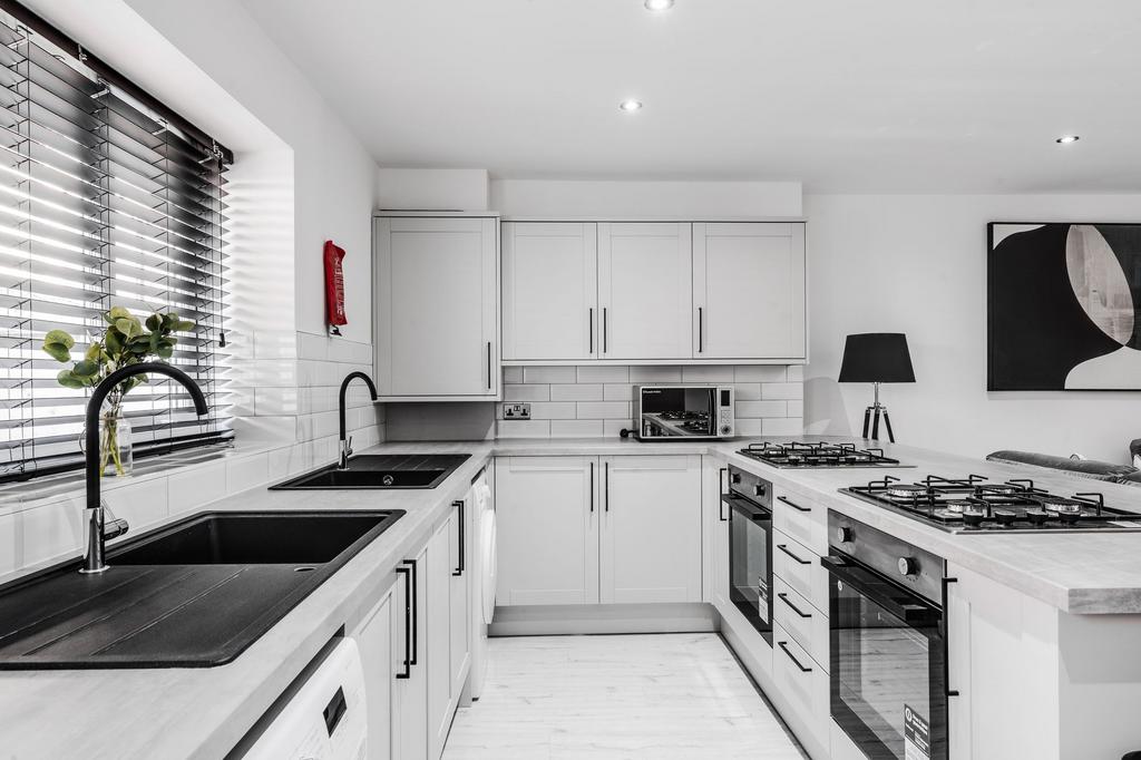 Modern and sleek kitchen with white cabinetry, ...