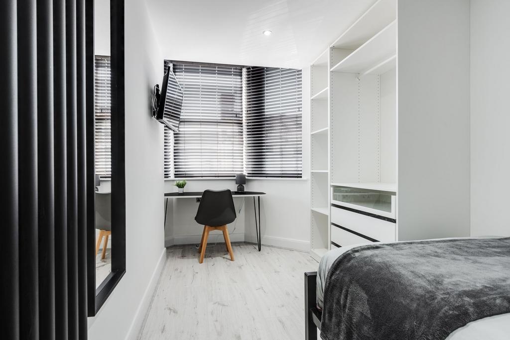 Modern, well-lit bedroom featuring sleek white ...