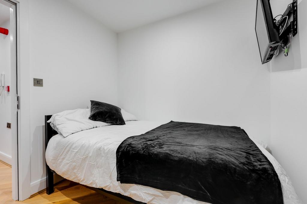 A comfortable, neatly made bedroom featuring a ...