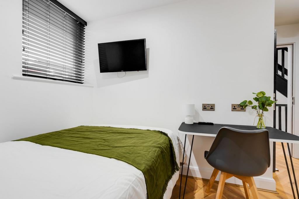 Bright and modern master bedroom featuring a la...