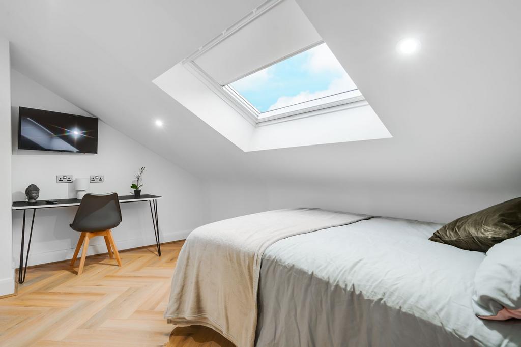 Bright and inviting bedroom with a large skylig...