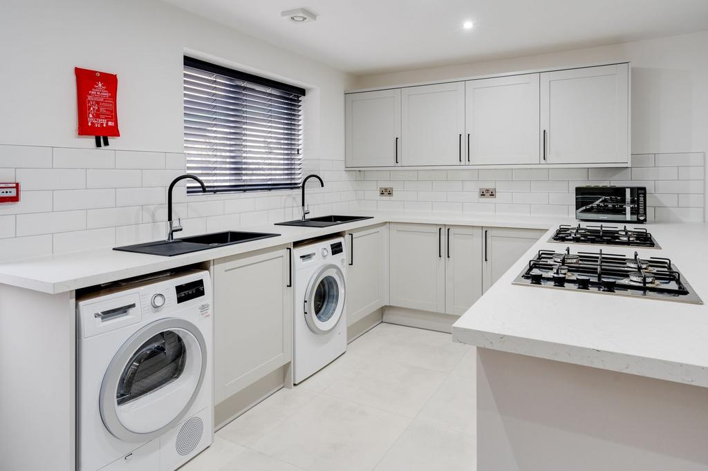 Modern, bright kitchen featuring white cabinetr...