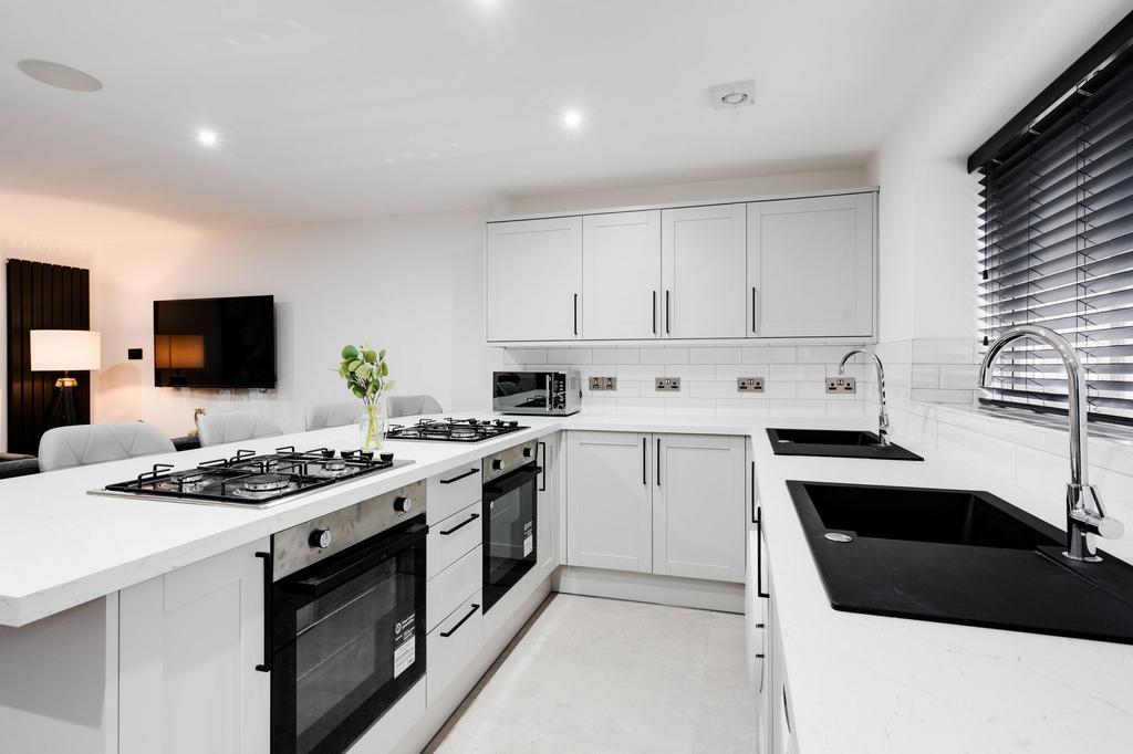 Modern and stylish kitchen featuring sleek whit...