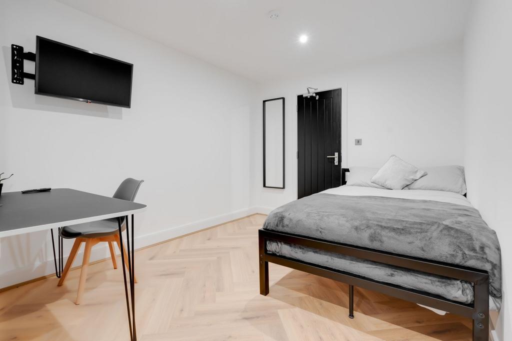A modern, minimalist bedroom featuring a comfor...