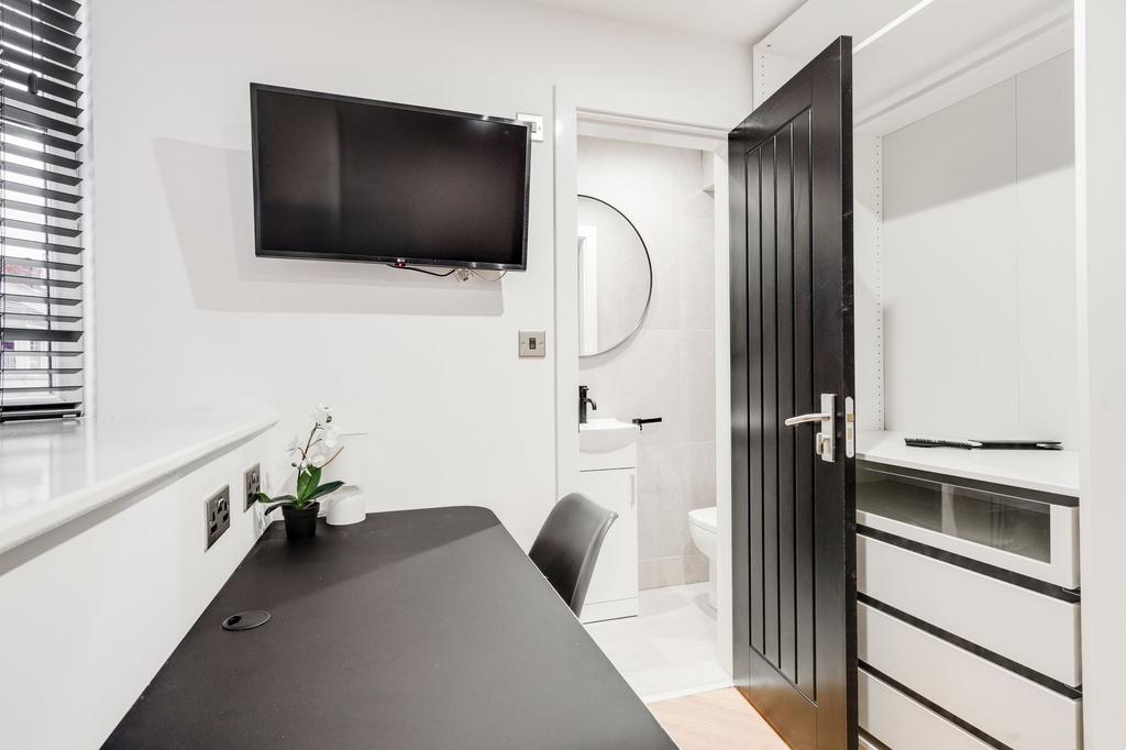 A clean modern bathroom with a white sink, roun...