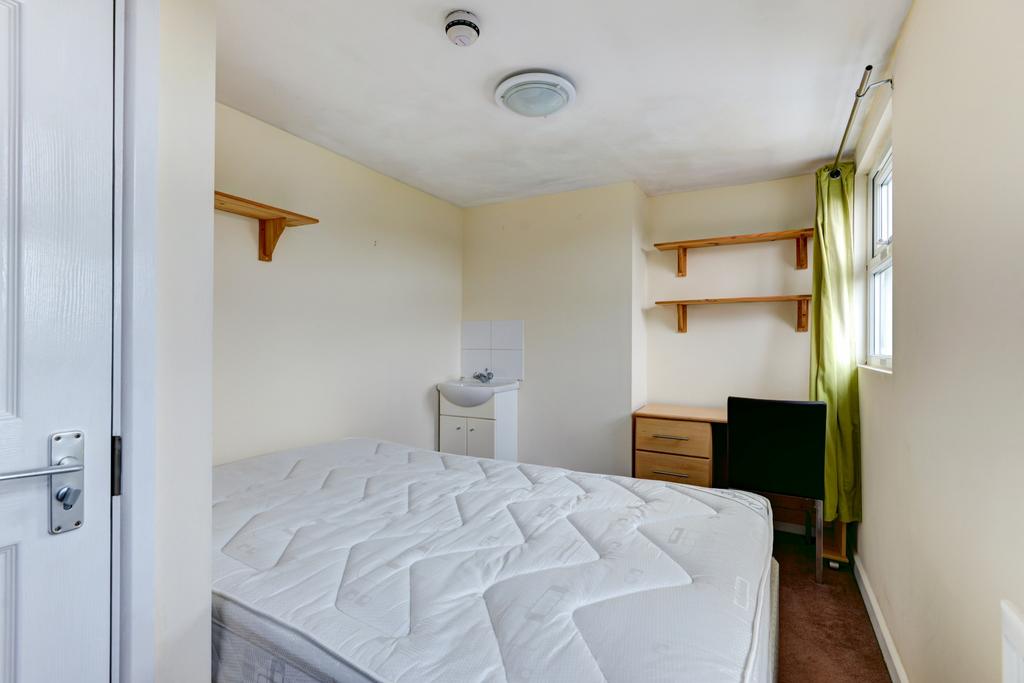 A bright and tidy bedroom featuring a comfortab...