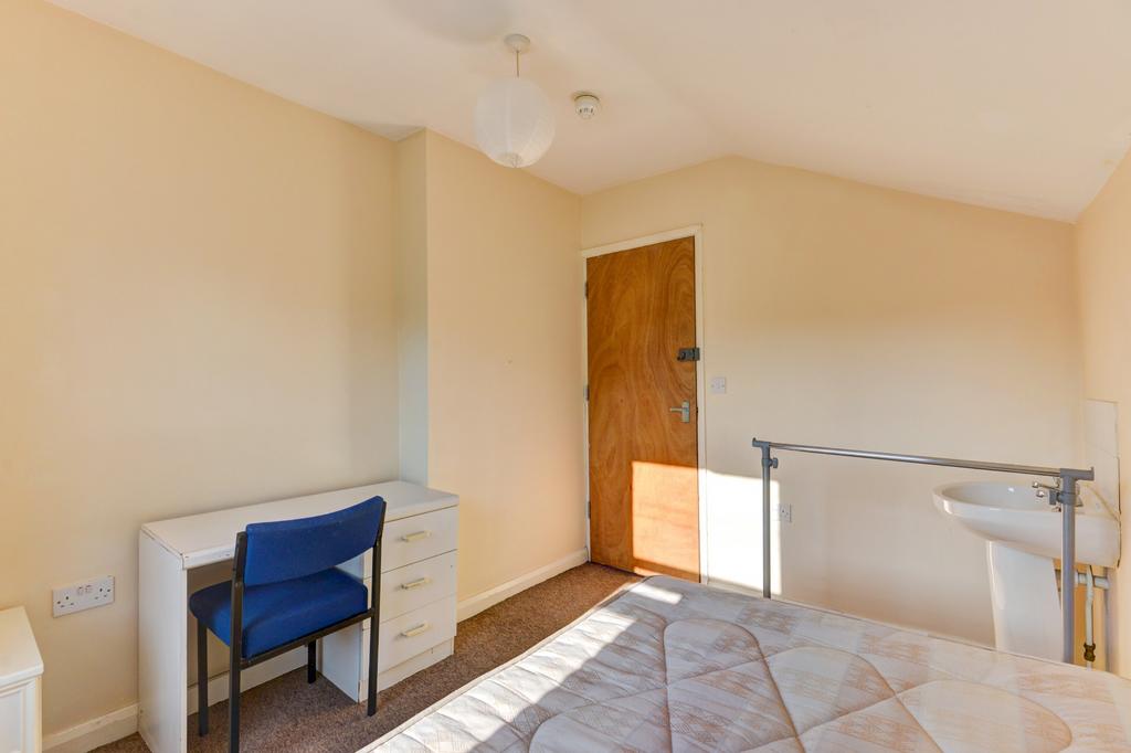 Bright and tidy bedroom with a large window all...