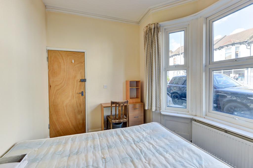A bright and inviting bedroom featuring a comfo...