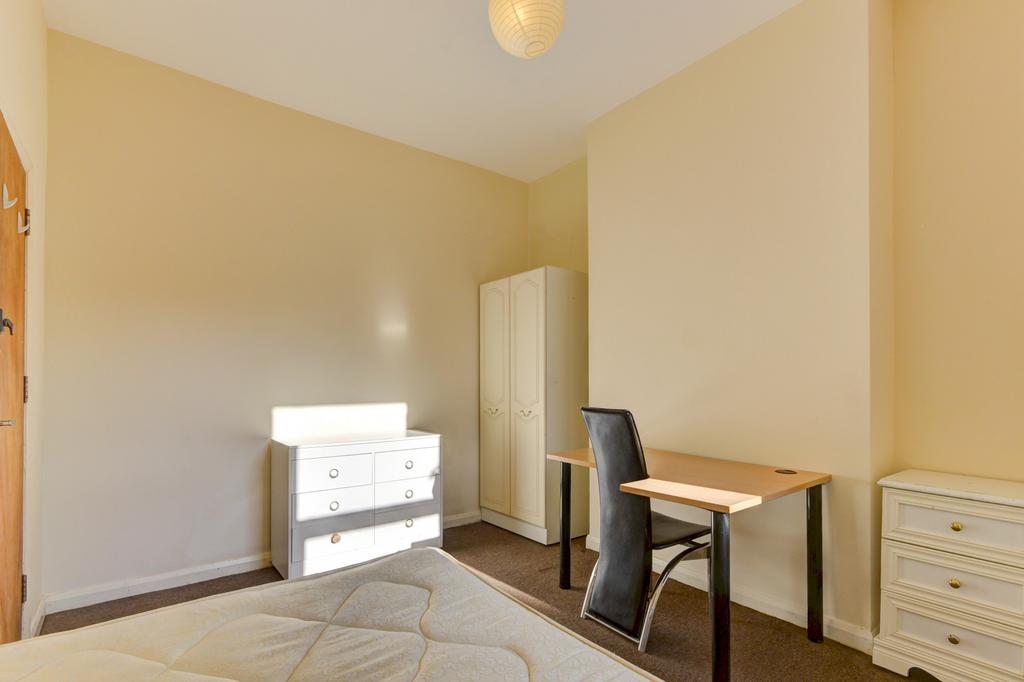 A bright and tidy bedroom featuring a large dou...