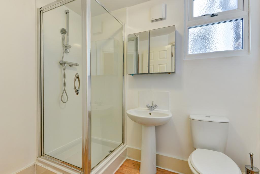 A bright and clean bathroom featuring a shower ...