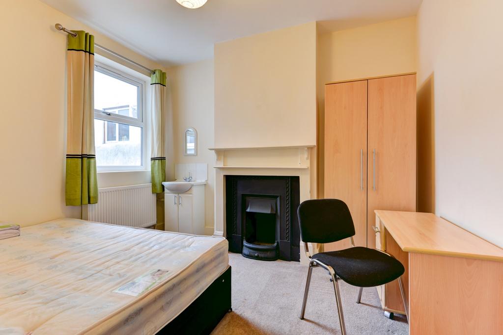 A bright and tidy bedroom featuring a comfortab...