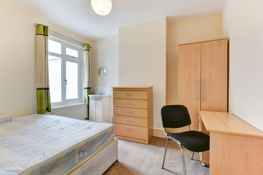 A bright and tidy bedroom featuring a double be...