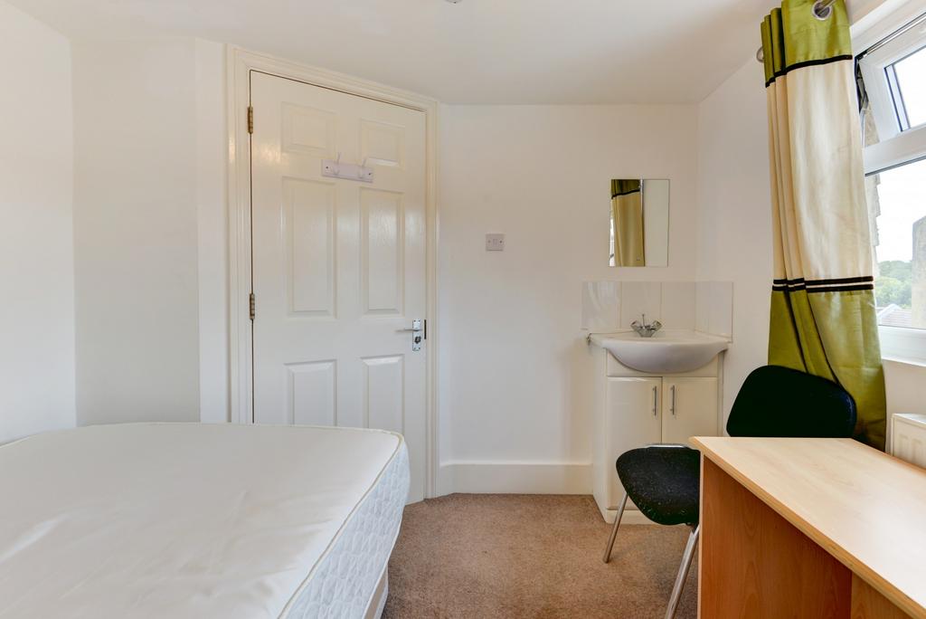 A bright and tidy bedroom featuring a comfortab...