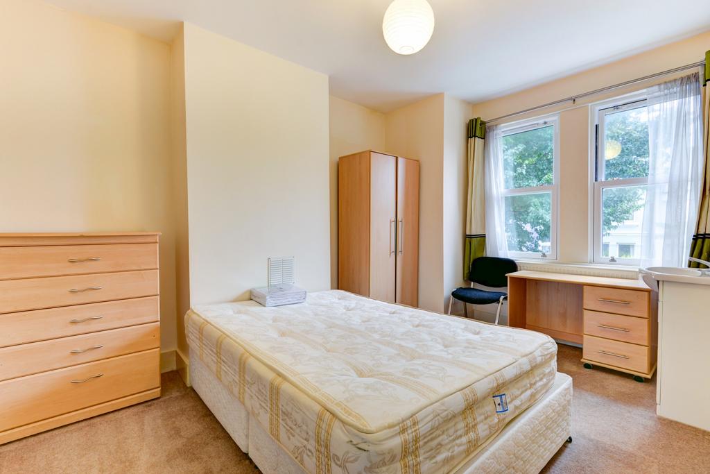 A cozy clean single bedroom with natural light ...