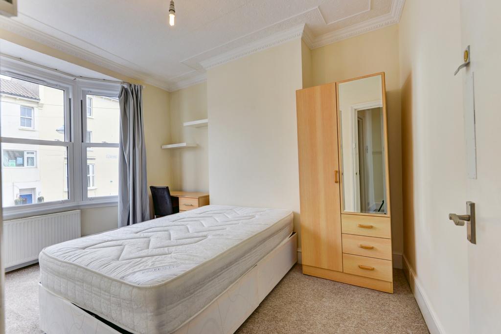 A bright and tidy single bedroom featuring a co...