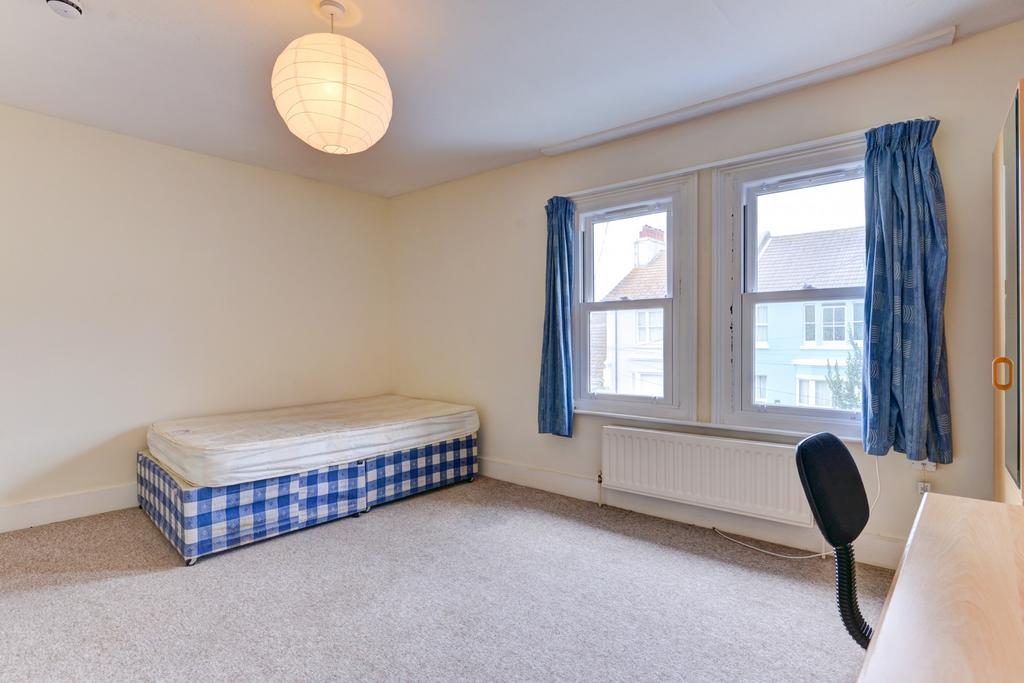 A bright and tidy single bedroom featuring a si...