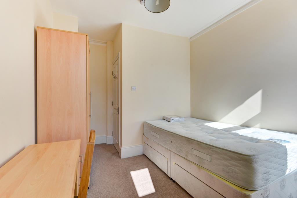 A cozy single bedroom featuring a bed positione...