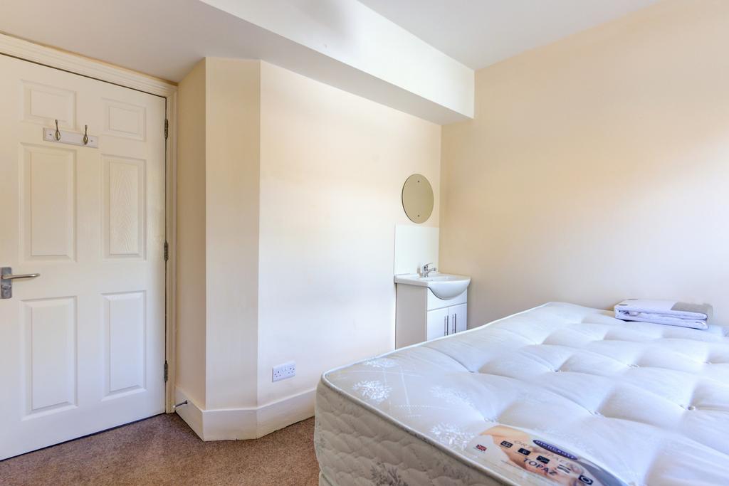 A well-lit bedroom featuring a comfortable doub...