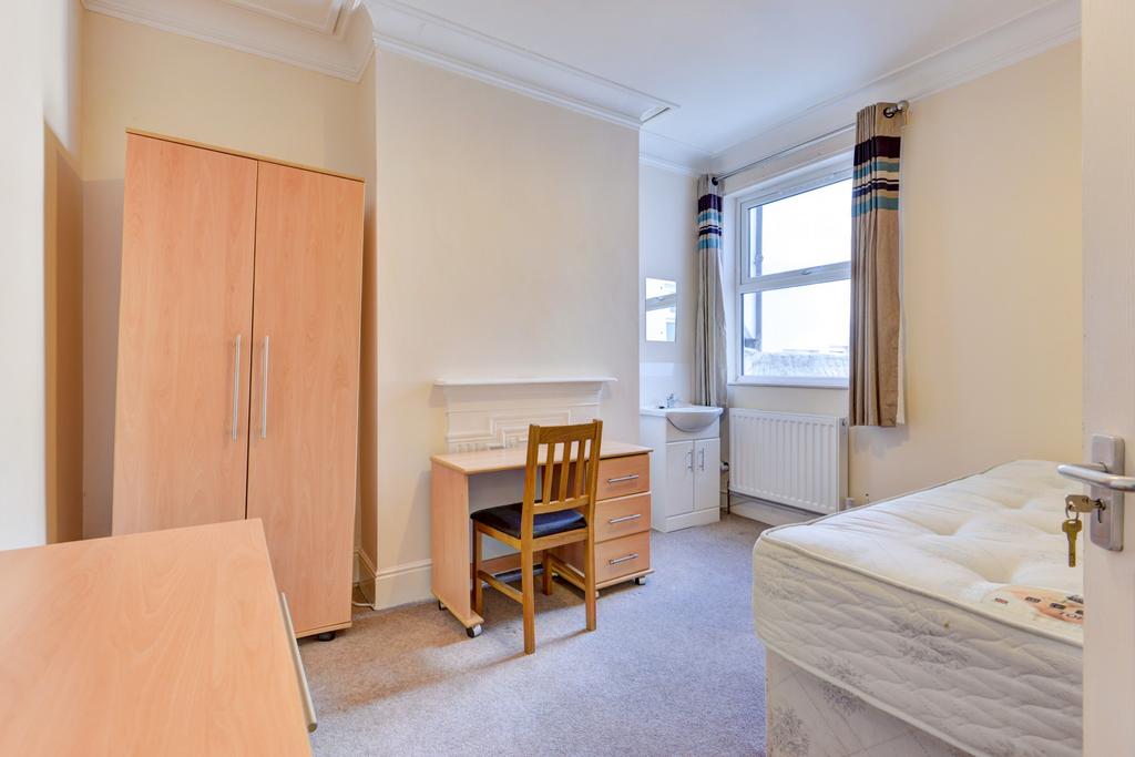 A clean and well-lit bedroom featuring a single...