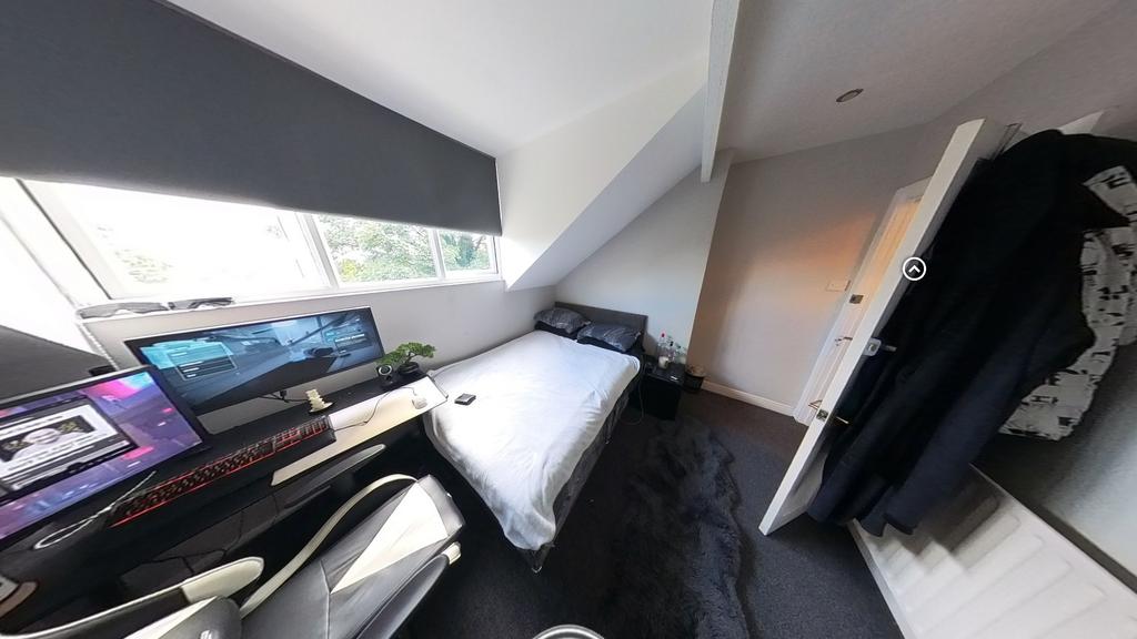 A cozy single bedroom featuring a bed with stor...