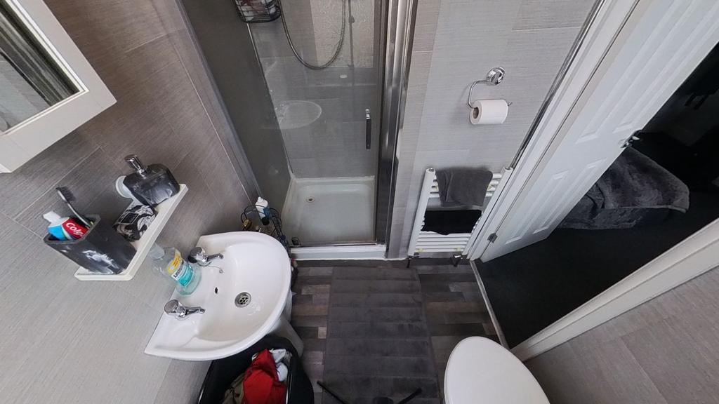 A modern bathroom with a shower, clean tiled wa...