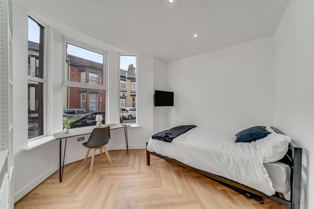 Bright and modern single bedroom featuring a la...