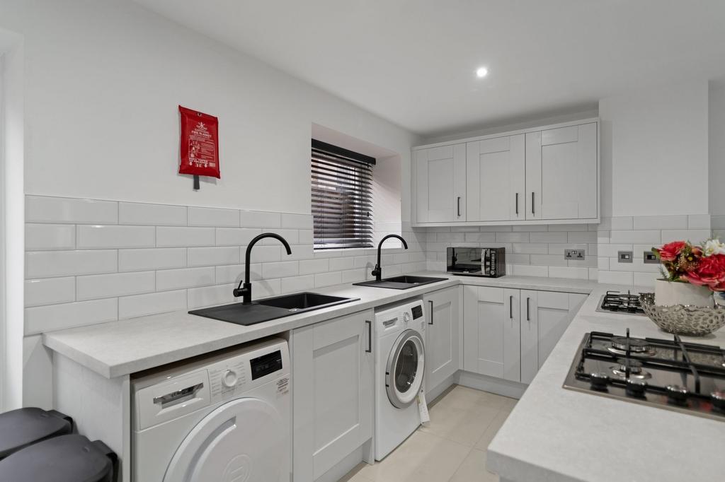 Modern and bright kitchen with sleek white cabi...