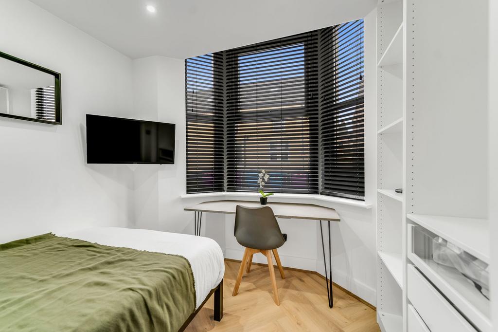 Bright and modern bedroom featuring a comfortab...