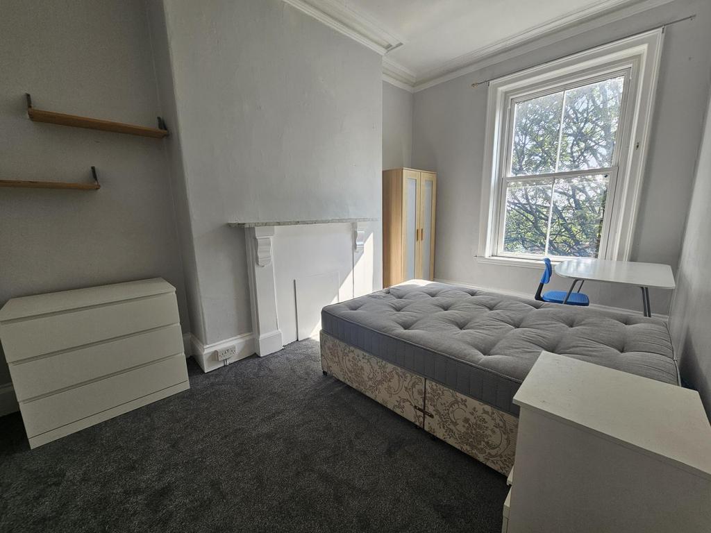 A cozy bedroom featuring a comfortable double b...