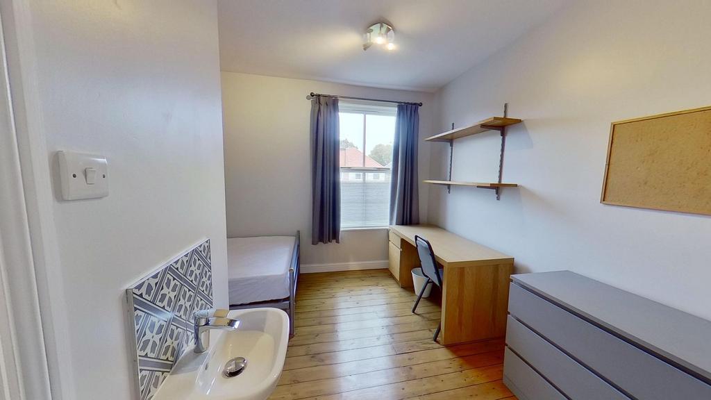 Bright, tidy bedroom with wooden floors, a stud...