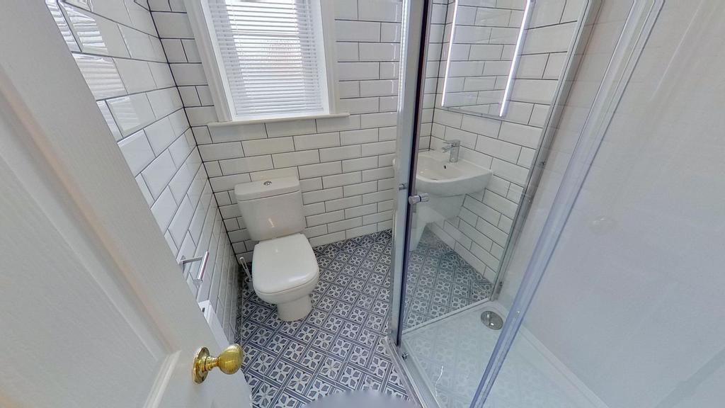 Bright, modern bathroom with patterned floor ti...
