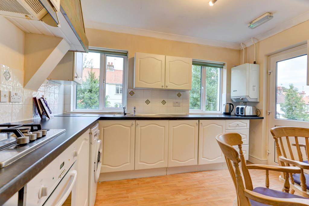 A bright and tidy kitchen with large windows al...