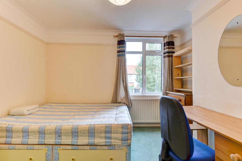 A bright and tidy bedroom featuring a comfortab...