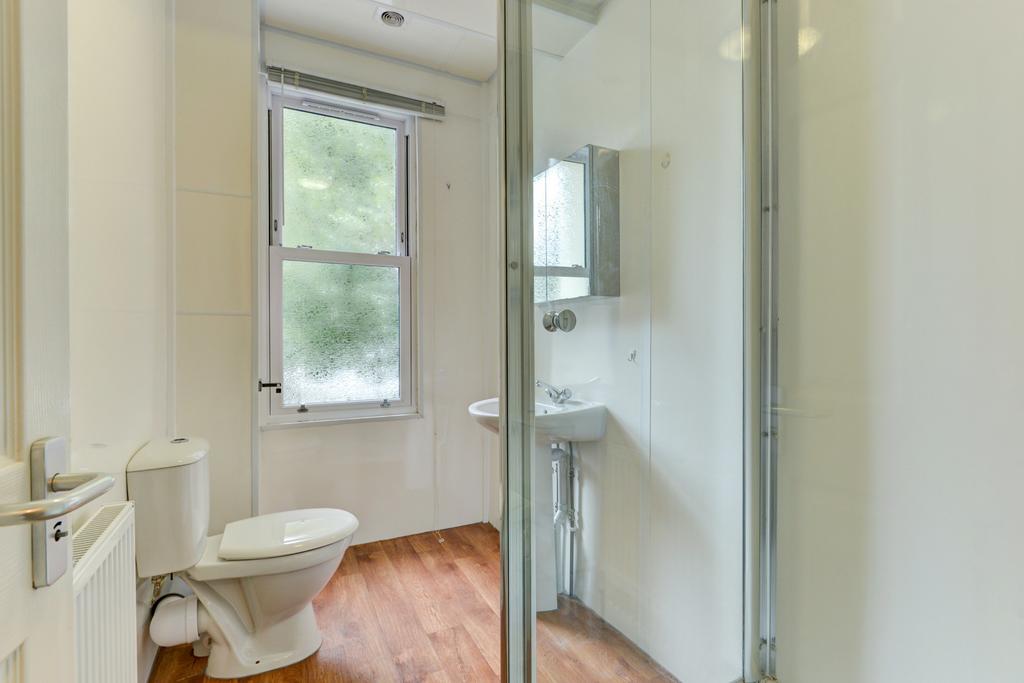 A bright, clean bathroom featuring a shower, to...