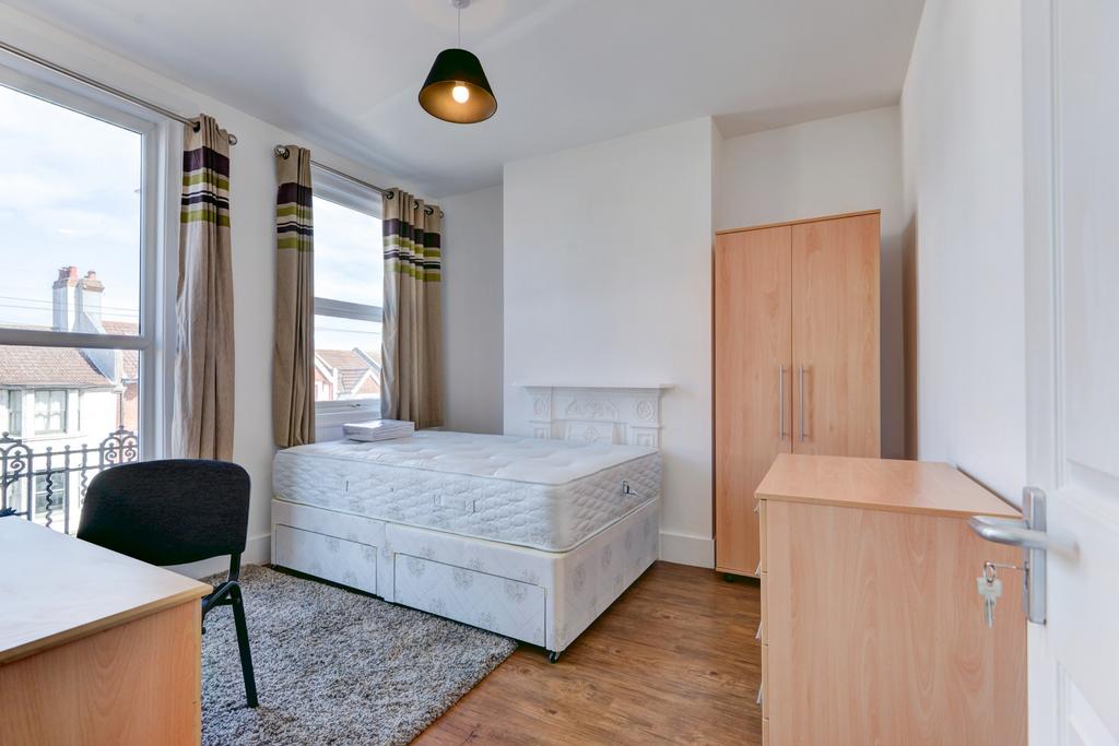 Bright and tidy bedroom featuring a spacious be...