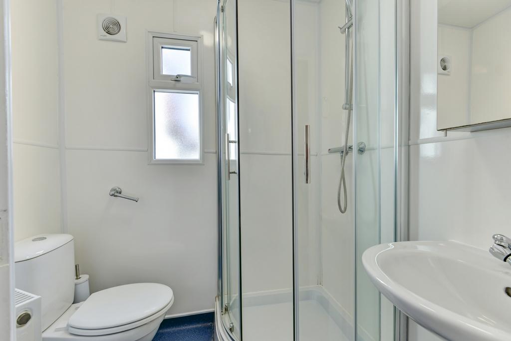 A clean and bright bathroom featuring a shower ...