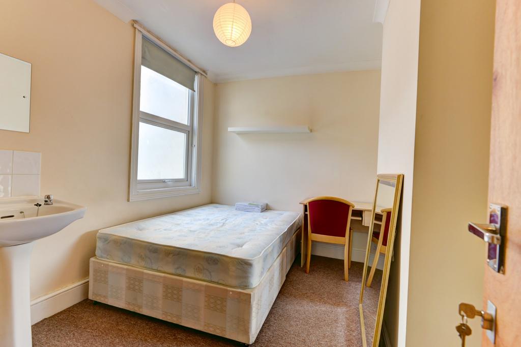 A cozy bedroom featuring a double bed, two chai...