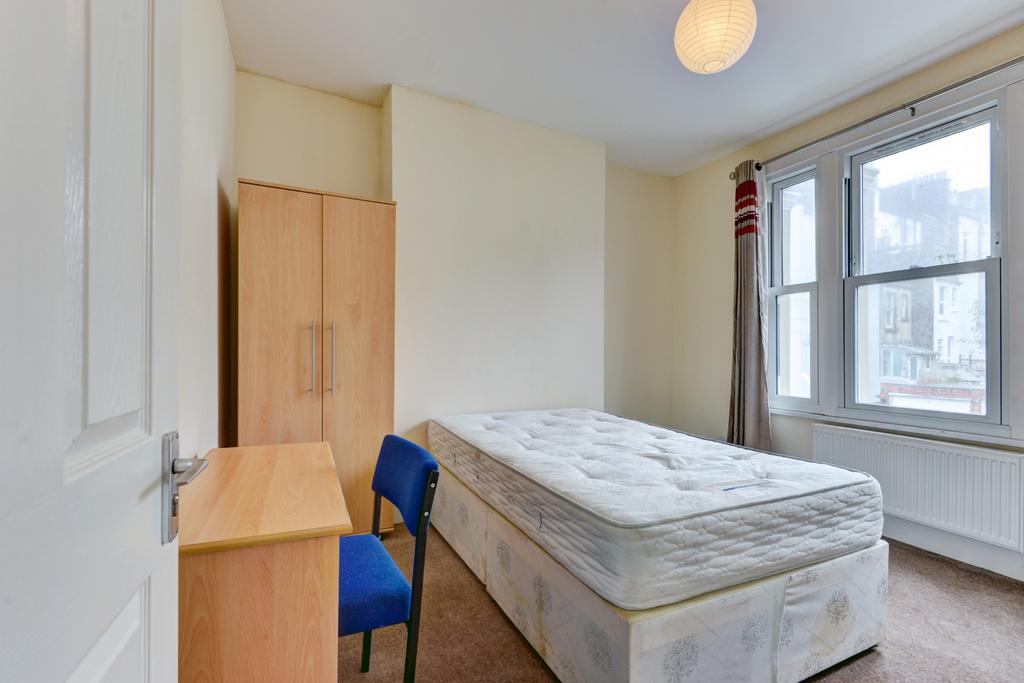 A bright and tidy single bedroom featuring a co...