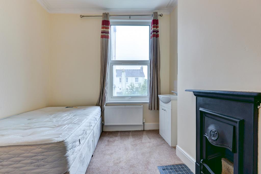 A cozy bedroom featuring a double bed, a window...